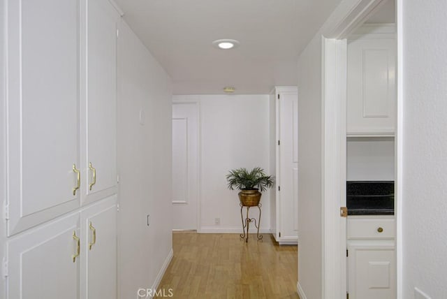 hallway with light hardwood / wood-style floors