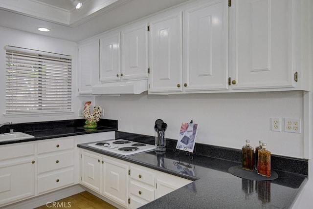 kitchen with white cabinets, ornamental molding, ventilation hood, and white cooktop