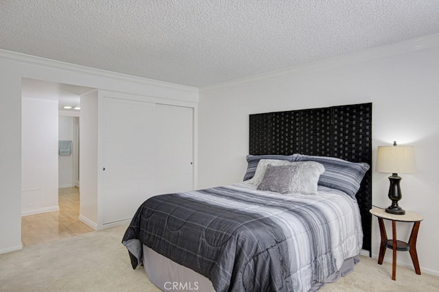 carpeted bedroom featuring crown molding, a textured ceiling, and a closet