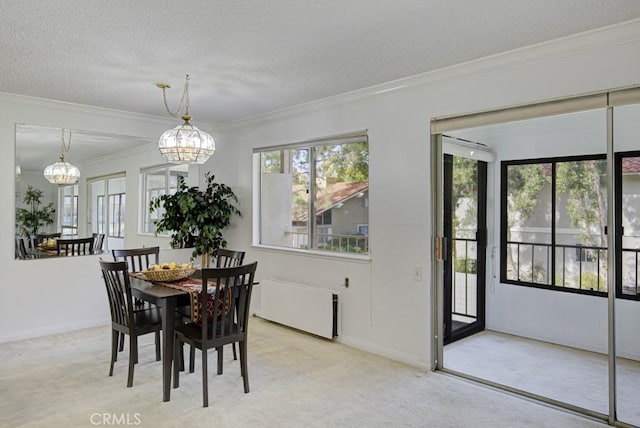 dining area featuring radiator, an inviting chandelier, light colored carpet, a textured ceiling, and ornamental molding