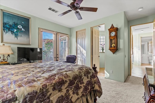 carpeted bedroom featuring ensuite bathroom, ceiling fan, and french doors