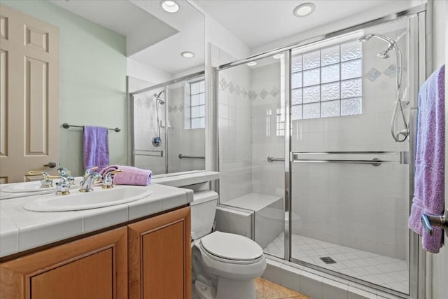 bathroom featuring tile patterned floors, vanity, toilet, and an enclosed shower