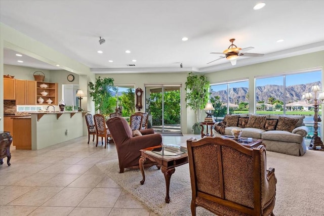 living room featuring a mountain view, ceiling fan, and light tile patterned floors