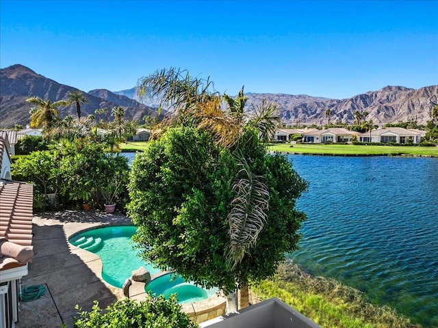 view of pool featuring a patio area, an in ground hot tub, and a water and mountain view