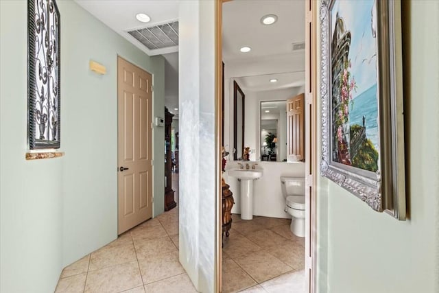 corridor with light tile patterned floors and sink