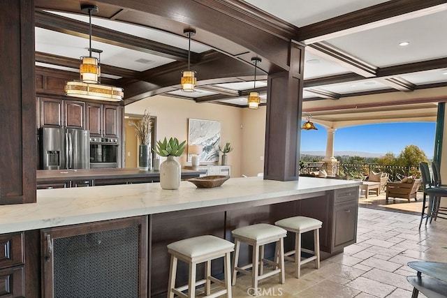 kitchen featuring hanging light fixtures, appliances with stainless steel finishes, beamed ceiling, dark brown cabinetry, and beverage cooler