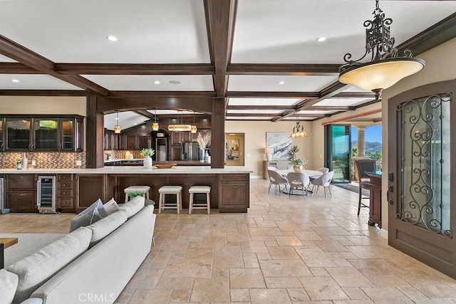 living room featuring beam ceiling, beverage cooler, and coffered ceiling