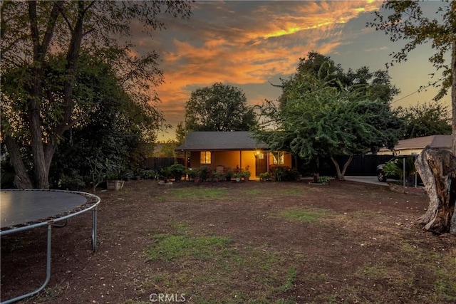 yard at dusk with a trampoline