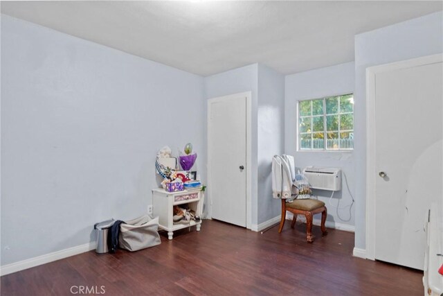 interior space featuring a wall mounted air conditioner and dark hardwood / wood-style floors