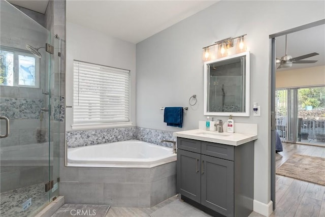 bathroom with wood-type flooring, vanity, separate shower and tub, and ceiling fan