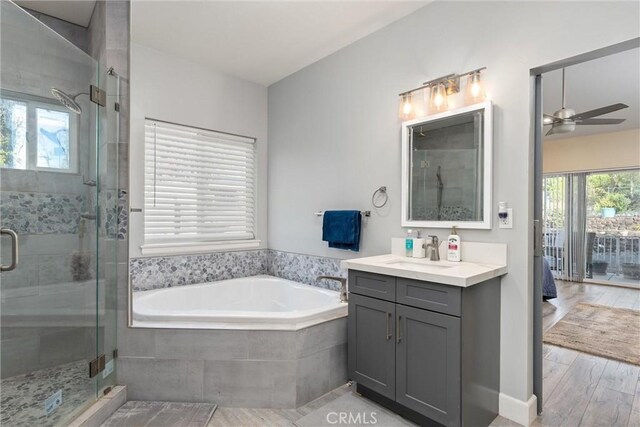 1486 Magadon Rd, Paradise, CA 95969 - ensuite bathroom featuring vanity, a ceiling fan, a garden tub, a shower stall, and wood finished floors