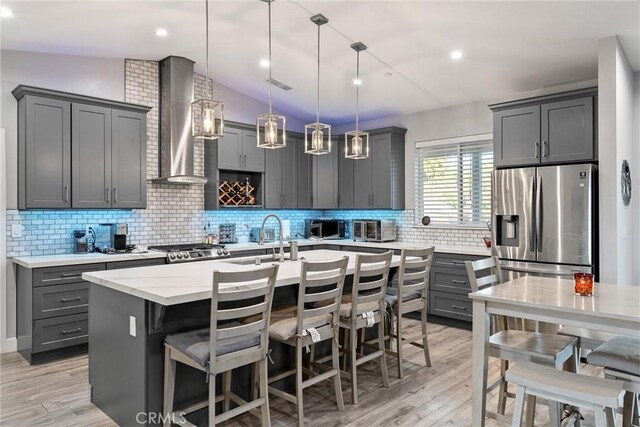 1486 Magadon Rd, Paradise, CA 95969 - kitchen with stainless steel refrigerator with ice dispenser, wall chimney range hood, gray cabinets, tasteful backsplash, and a center island with sink