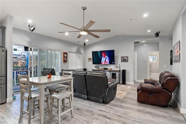 living room featuring ceiling fan, vaulted ceiling, and light hardwood / wood-style flooring