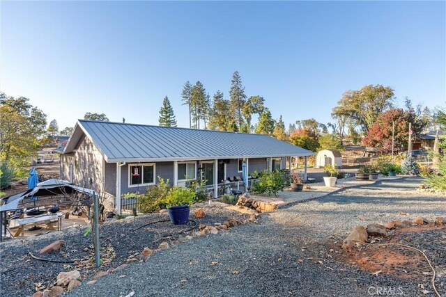 1486 Magadon Rd, Paradise, CA 95969 - view of front facade featuring a storage unit, a metal roof, a porch, and a standing seam roof