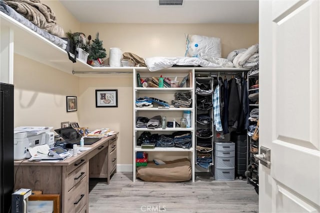 walk in closet with light wood-type flooring