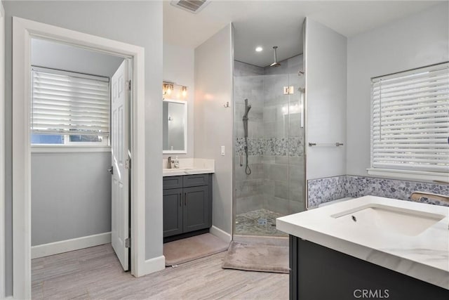 bathroom with a shower with door, vanity, and wood-type flooring