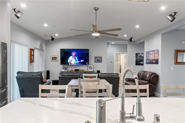 interior space featuring ceiling fan, sink, and lofted ceiling