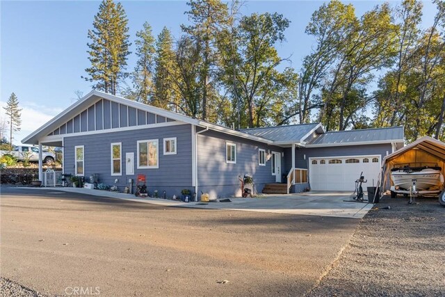 1486 Magadon Rd, Paradise, CA 95969 - view of front facade featuring an attached garage, concrete driveway, board and batten siding, and a metal roof
