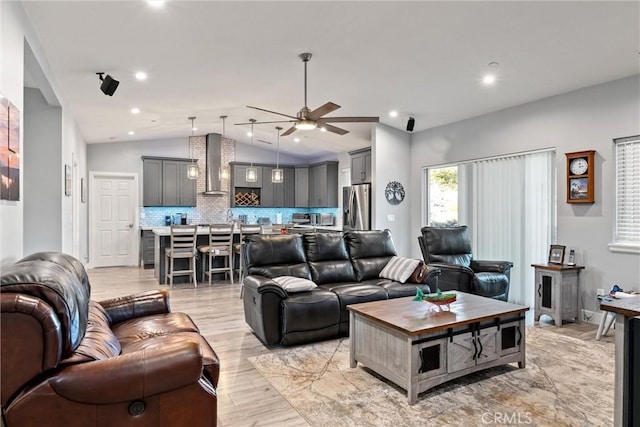 living room with light hardwood / wood-style flooring, ceiling fan, and lofted ceiling