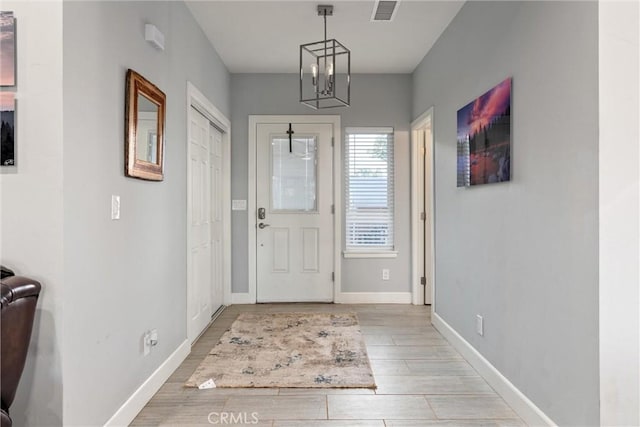 entryway featuring light hardwood / wood-style floors and an inviting chandelier