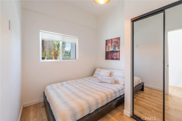 bedroom with light hardwood / wood-style flooring and a closet