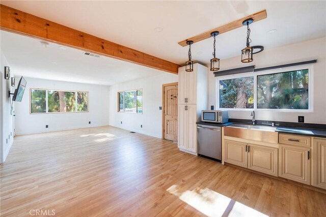 kitchen with pendant lighting, beamed ceiling, light hardwood / wood-style floors, and appliances with stainless steel finishes