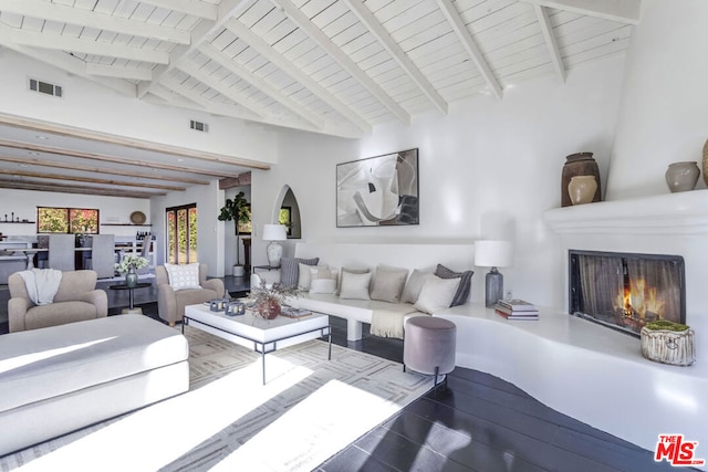 living room featuring a fireplace, high vaulted ceiling, and beamed ceiling