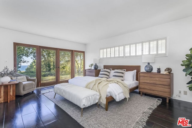 bedroom featuring multiple windows and dark hardwood / wood-style floors