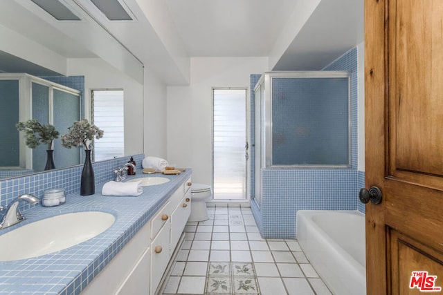 full bathroom featuring tile patterned floors, vanity, shower with separate bathtub, and a wealth of natural light