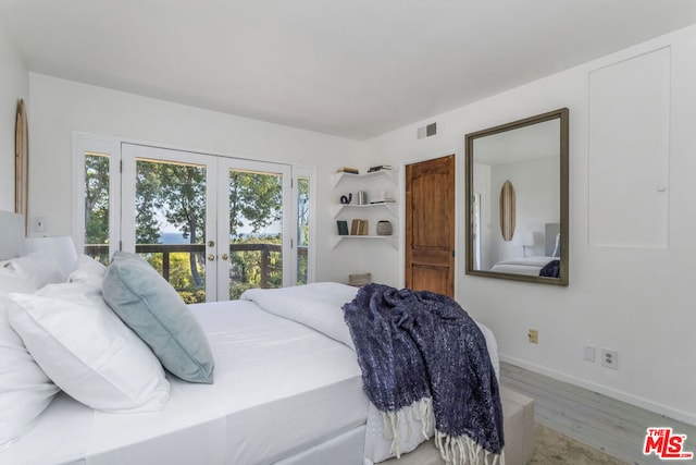 bedroom featuring light wood-type flooring and french doors