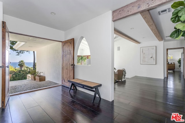 hallway with beamed ceiling, dark hardwood / wood-style flooring, and a healthy amount of sunlight