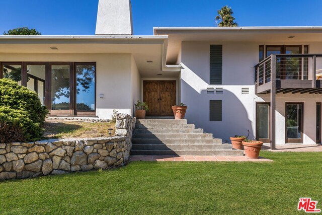 entrance to property featuring a yard