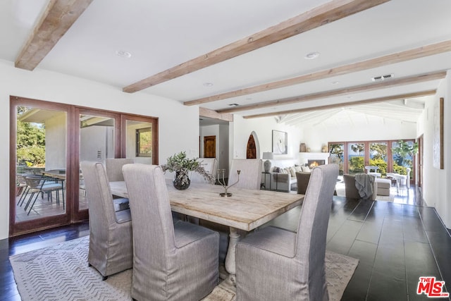 dining area featuring lofted ceiling with beams, dark hardwood / wood-style flooring, and french doors