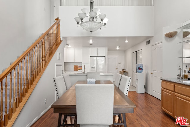 dining room featuring a chandelier, sink, and dark wood-type flooring