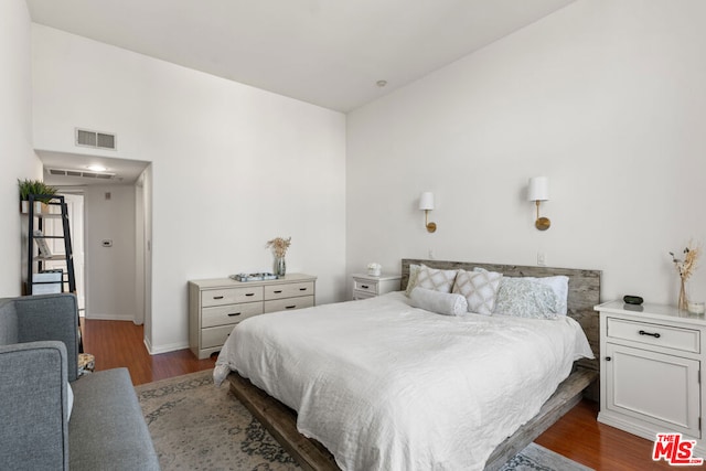 bedroom with dark wood-type flooring and vaulted ceiling