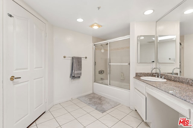 bathroom featuring vanity, tile patterned floors, and enclosed tub / shower combo