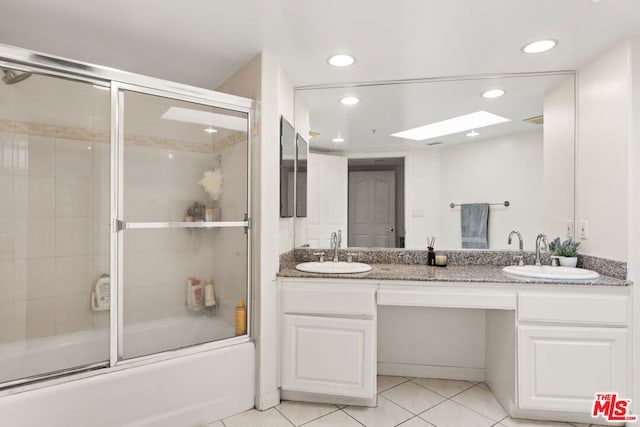 bathroom with vanity, tile patterned floors, and bath / shower combo with glass door