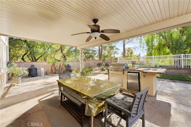 view of patio / terrace featuring ceiling fan, area for grilling, and exterior kitchen