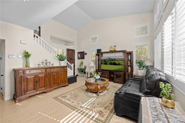 living room with high vaulted ceiling and light hardwood / wood-style flooring