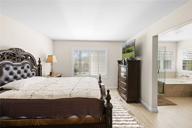 bedroom with multiple windows and light wood-type flooring