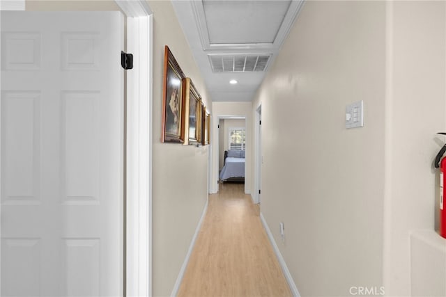 hall with light wood-type flooring and crown molding