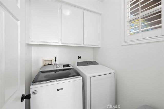 laundry room featuring washing machine and clothes dryer and cabinets