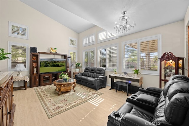 living room featuring high vaulted ceiling, a chandelier, and light wood-type flooring