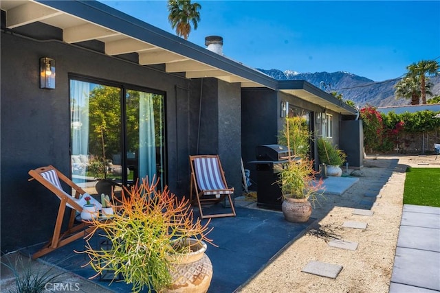 view of patio with area for grilling and a mountain view