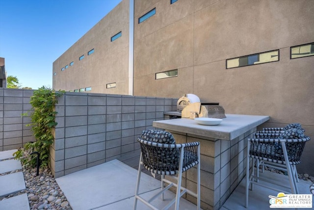 view of patio / terrace with exterior bar and an outdoor kitchen