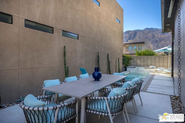 view of patio / terrace featuring a mountain view and a swimming pool with hot tub