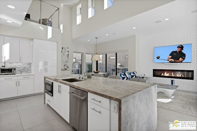 kitchen featuring white cabinetry, sink, and a kitchen island with sink