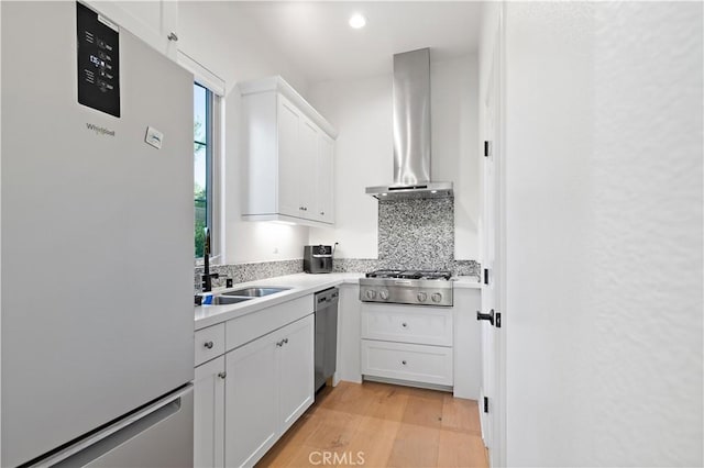 66 Poncho, Irvine, CA 92602 - kitchen with appliances with stainless steel finishes, light countertops, white cabinetry, light wood-style floors, and wall chimney exhaust hood