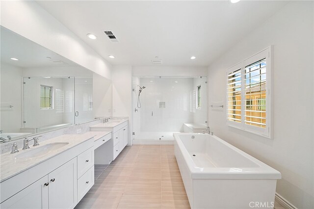 66 Poncho, Irvine, CA 92602 - full bathroom featuring a stall shower, two vanities, a soaking tub, and recessed lighting