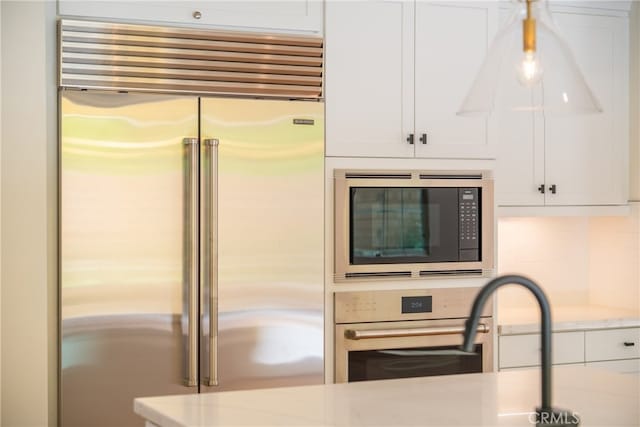 66 Poncho, Irvine, CA 92602 - kitchen with built in appliances, white cabinetry, light stone countertops, and decorative backsplash